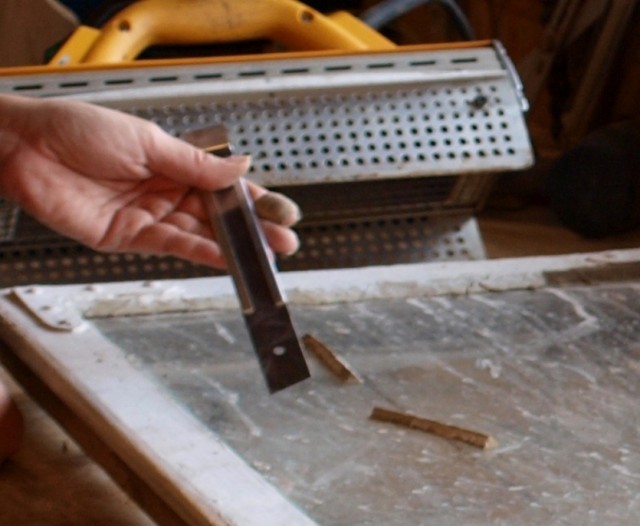 Her benyttes lillskrapen til å pirke bort gammelt inntørket linoljekitt - Foto: Gamletrehus.no