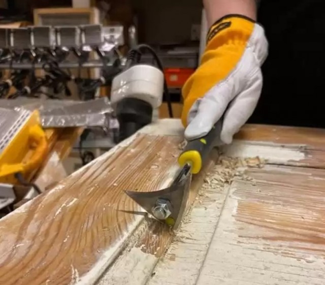 Speedheater bumerangskrape har mange bruksområder, her benyttet til å skrape bort maling fra profiler på et dørblad