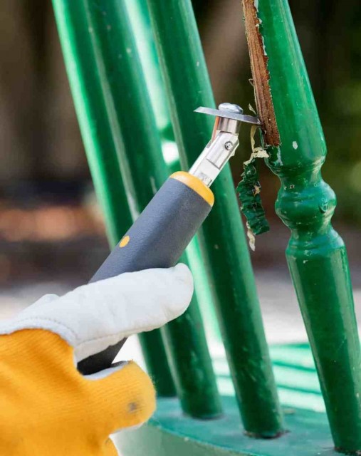 Bladene er målrettet finarbeide, her skrapes maling fra spiler på en kjøkkenstol..